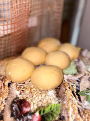 Six soft dough balls sit on textured surface, fresh preparation for bread or baking. Ingredients...