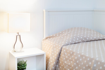 Room with a 90cm grey wooden trundle bed, white square nightstand, lamp and white wall, bath towels, rental house, vacation rental, bedroom