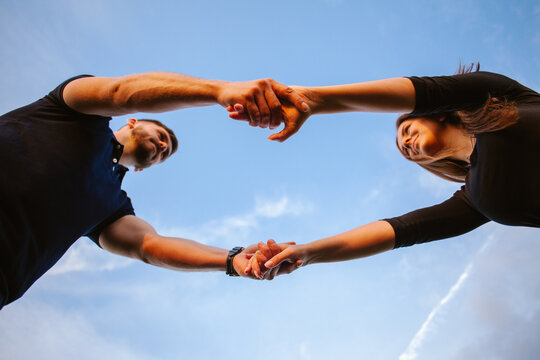 Loving couple holding hands under blue sky