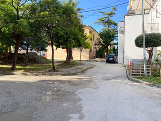 Small-town scenery in Albania with typical houses, electric lines, and surrounding greenery. A tranquil urban moment ideal for travel content or lifestyle publications.