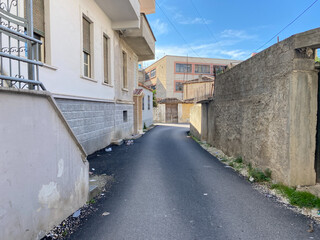Residential view of rural Albania showing modest homes, electric cables, and greenery creeping through cracks. A peaceful and authentic moment perfect for editorial or travel use.