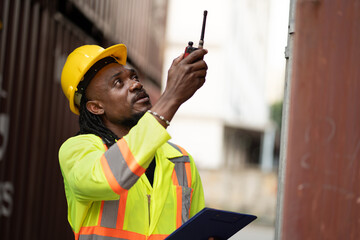 African worker working with use clipboard checking container at container site	