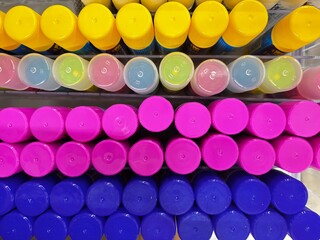 Pink and blue tubes standing in a row, top view