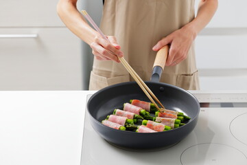 フライパンでアスパラベーコンを焼く料理のシーン　Asparagus Bacon Being Cooked in a Frying Pan