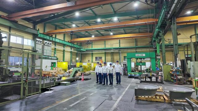 Group of workers standing in a factory.