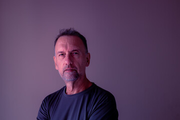 A man between 55 and 60 years old, looking young and calm, looking at the camera. Single adult.