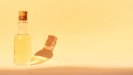 Isolated plastic bottle container with liquid soap inside on sunlit salmon background. Container...