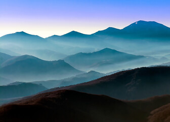 Blue mountain range with fog filling the valleys at dawn, Picos de Europa - Spain 