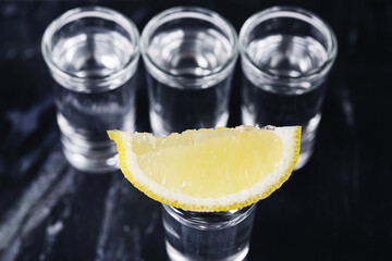 Vodka shots with lemon slice. Three glasses arranged in row. Party mood and fun vibes. Chilled...