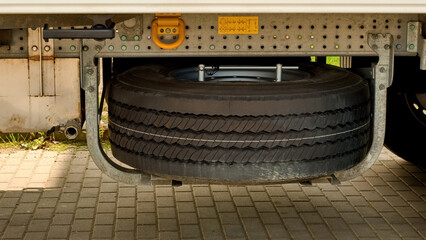 Fototapeta premium Spare wheel under the trailer frame.