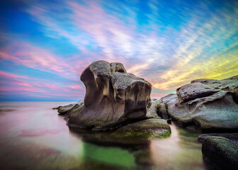 Rocks emerging from the sea at sunset with colorful sky