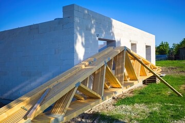 Wooden Roof Trusses at Modern House Construction Site. Prefabricated Roof Trusses on Ground Before...