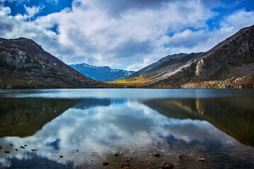 Fototapeta premium Lake Calabazosa reflecting cloudy sky in Somiedo Natural Park