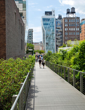 Unidentifiable people walking along the High Line walkway in New York City