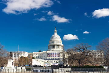 US Capitol in Washington DC in winter. Cityscape with blue sky and clouds above the dome.