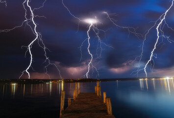 Wooden pier during a thunderstorm, Long exposure. Dramatic sky with lightings.
