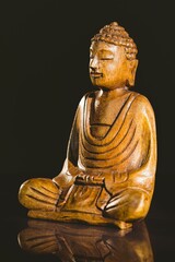 Buddha statue on table against black background