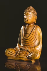 Buddha statue on table against black background