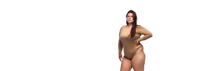 A plus-size model exudes confidence in a fashionable, earthy-toned bodysuit against a white...