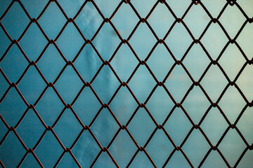 Fototapeta premium Rusty Chain Link Fence Against Blue Background