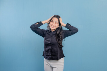 A woman in a black shirt is holding her head and laughing. Concept of humor and lightheartedness