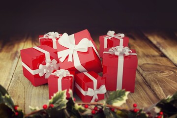 Flat design red gift boxes with white ribbons are forming cluster on tabletop with holly sprigs