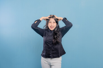 A woman in a black shirt is holding her head and laughing. Concept of humor and lightheartedness