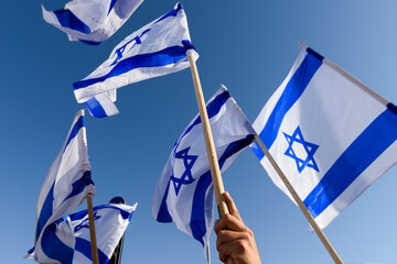 Blue and white flags of the State of Israel held aloft during the celebration parade of Jerusalem...