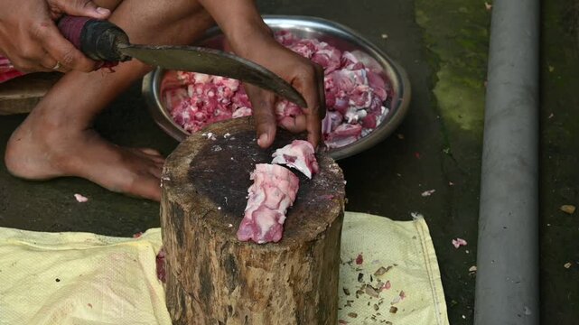 Chopping goat meat. Fresh raw or uncooked goats mutton cutting from Traditional iron tool in Indian village life. chopping goat meat into small pieces. Slow motion video. 
