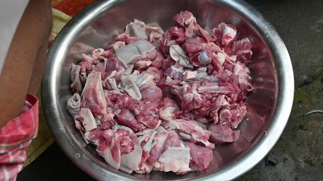Chopping goat meat. Fresh raw or uncooked goats mutton cutting from Traditional iron tool in Indian village life. chopping goat meat into small pieces. Slow motion video. 
