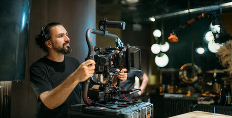 Director of photography with a camera in his hands on the set. Professional videographer at work on...