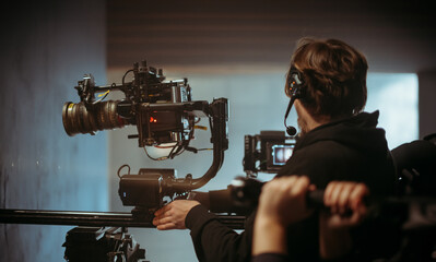 Director of photography with a camera in his hands on the set. Professional videographer at work on...