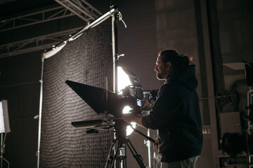 The director of photography with a camera on the set. A professional videographer is working on...