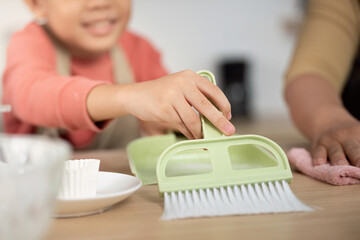 Family Cleaning Time. A child enthusiastically helps with kitchen cleaning tasks.
