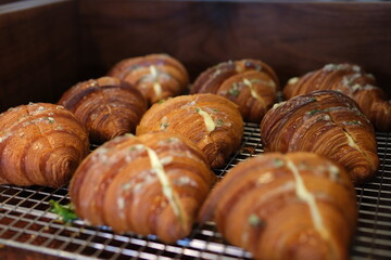 Golden brown croissants are neatly arranged on wooden boards, alongside other pastries like donuts and slices of pound cake, possibly at a breakfast buffet or bakery display. High quality 4k footage
