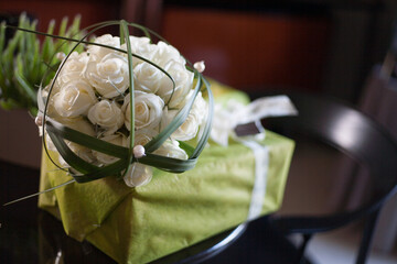 This stunning arrangement of pure white roses resting on a vibrant green gift is perfect for any...