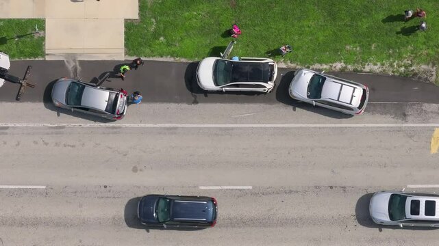 First responders responding to car accident site on American street. Emergency services helping victims of vehicle crash on road in USA.