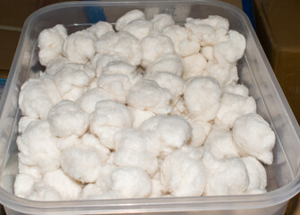 sterilized white cotton balls neatly stored in a clean, transparent box, commonly used in hospitals, clinics, and medical setups. essential medical supplies for wound care, injections.
