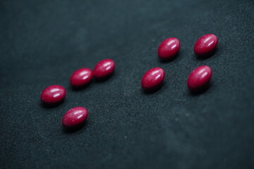 Bright red, round tablets often feature a smooth, glossy finish. Typically used for medications or supplements, they may vary in size and imprint, designed for easy identification and swallowing.