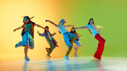 Youthful dancers in vibrant space embody urban culture and creativity through dynamic group...