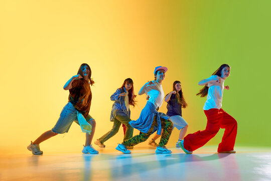 Youthful dancers showcase vibrant moves in a colorful urban setting, expressing creativity and energy. Concept of modern dance culture in city environments.