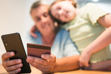 Smiling caucasian grandmother and granddaughter enjoying time together with smartphone.	
