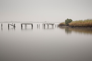  Ruined river pier in a foggy morning