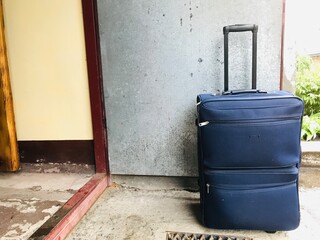 Travel suitcase placed at the entrance of a building