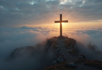 Obraz premium A majestic cross stands atop a mountain, illuminated by a stunning sunset