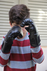 
Boy with boxing gloves in a defensive stance