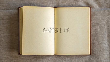 Open book with chapter one me inscription on the blank pages over fabric background