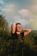 Happy girl with closed eyes and smile in mountains in embroidered shirt