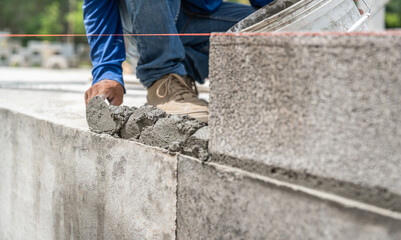 Hand worker masonry brickwork trowel construction site wall concrete background