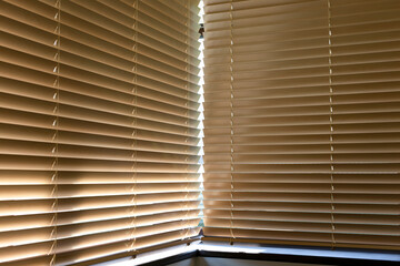 Motorized wood blinds cover two adjacent windows, filtering sunlight with ease. Made from natural...